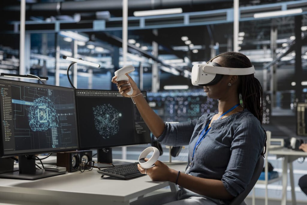Mulher em um escritório de tecnologia, usando óculos de realidade virtual e controles manuais, representando o setor que cria os novos milionários.